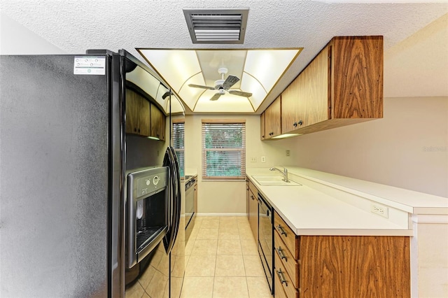 kitchen with ceiling fan, sink, a textured ceiling, light tile patterned flooring, and black appliances