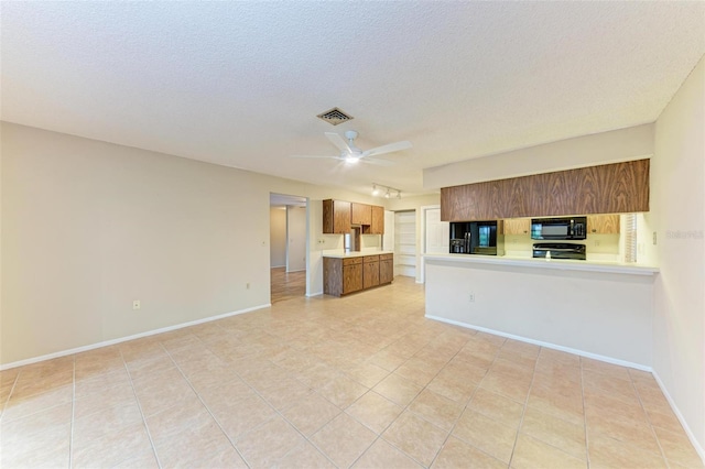 kitchen featuring ceiling fan, kitchen peninsula, a textured ceiling, light tile patterned flooring, and black appliances