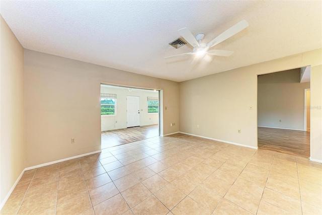 unfurnished room featuring ceiling fan, a textured ceiling, and light hardwood / wood-style flooring