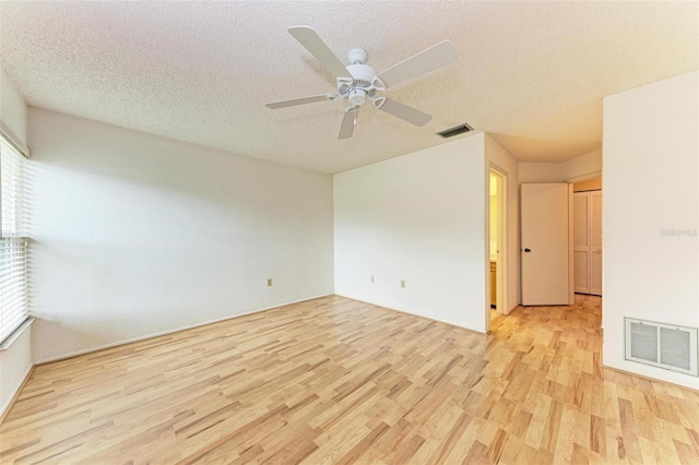 spare room featuring ceiling fan, a textured ceiling, and light hardwood / wood-style flooring