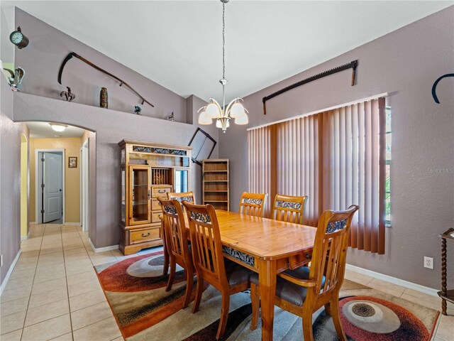 dining space with vaulted ceiling, a chandelier, and light tile patterned floors