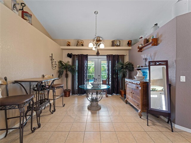 tiled dining space with french doors, vaulted ceiling, and a notable chandelier