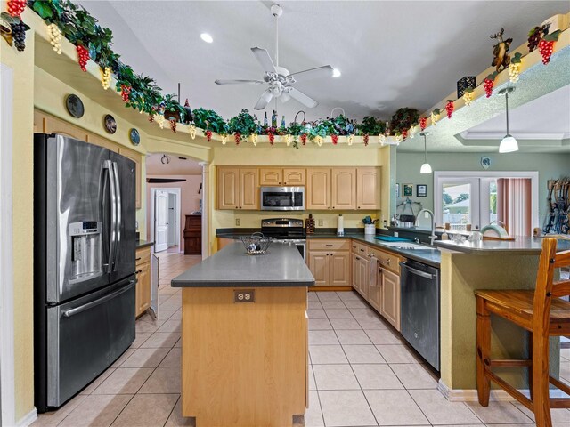 kitchen featuring kitchen peninsula, a center island, sink, ceiling fan, and appliances with stainless steel finishes