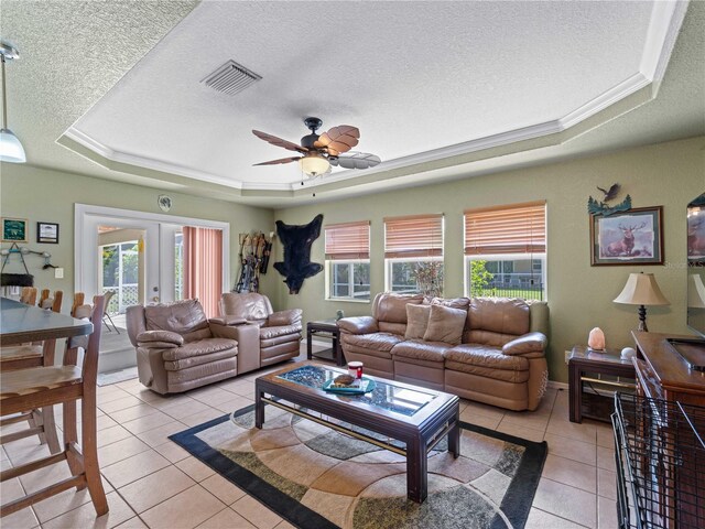 living room with a raised ceiling, ceiling fan, light tile patterned floors, and french doors