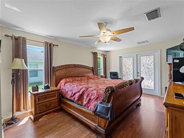 bedroom with a textured ceiling, access to exterior, ceiling fan, and hardwood / wood-style floors