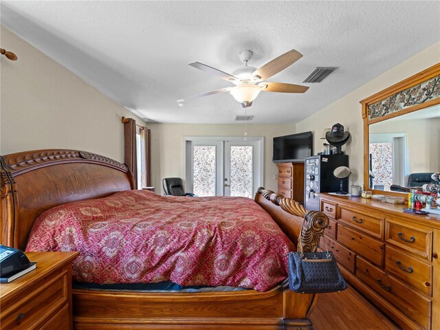 bedroom featuring french doors, a textured ceiling, hardwood / wood-style floors, and ceiling fan