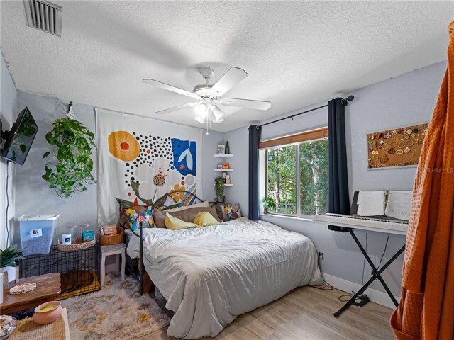 bedroom featuring ceiling fan, a textured ceiling, and light hardwood / wood-style flooring