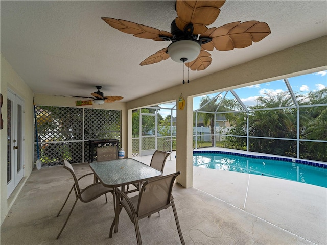 view of swimming pool featuring ceiling fan, a patio area, and glass enclosure