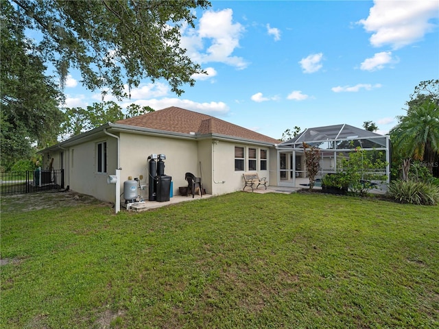 back of house with a lawn, a lanai, and a patio