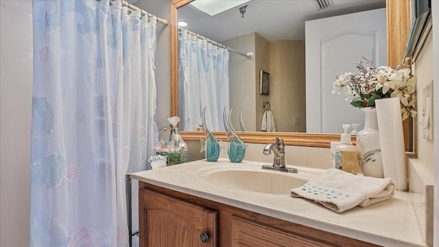bathroom with curtained shower and vanity
