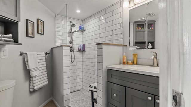 bathroom with toilet, walk in shower, vanity, and visible vents