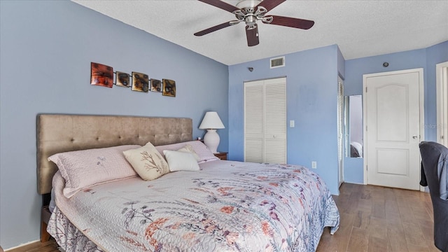 bedroom featuring a textured ceiling, hardwood / wood-style floors, and ceiling fan