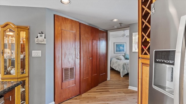 hall featuring light wood-type flooring, baseboards, visible vents, and recessed lighting