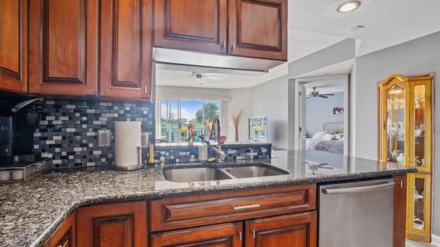 kitchen featuring ceiling fan, sink, backsplash, dishwasher, and dark stone counters