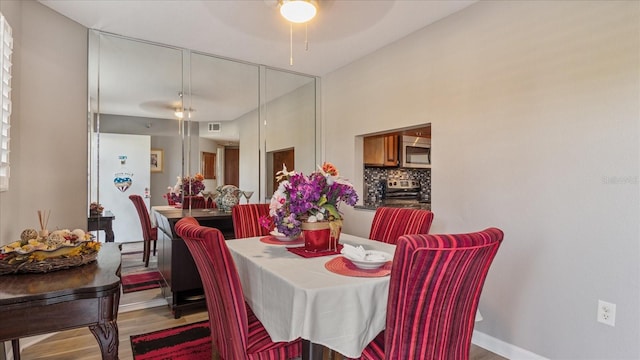 dining area featuring wood-type flooring and ceiling fan