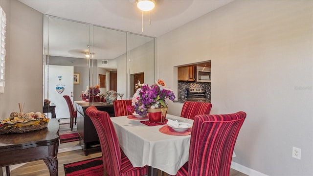 dining area featuring a ceiling fan, wood finished floors, and visible vents