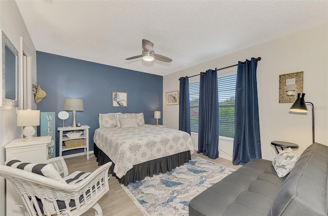 bedroom featuring ceiling fan, a textured ceiling, and light hardwood / wood-style flooring