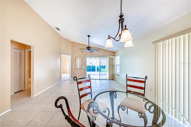 dining space featuring lofted ceiling, ceiling fan, light tile patterned floors, and a textured ceiling