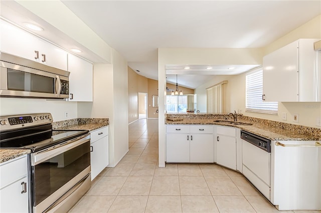 kitchen with lofted ceiling, stainless steel appliances, white cabinetry, and sink