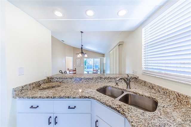 kitchen with white cabinets, vaulted ceiling, decorative light fixtures, plenty of natural light, and sink