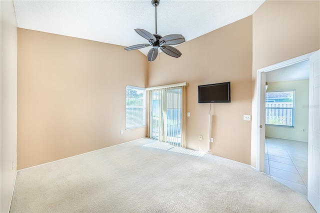 carpeted spare room with a high ceiling, ceiling fan, and a textured ceiling