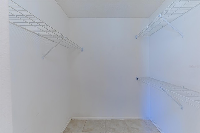 walk in closet with light tile patterned floors