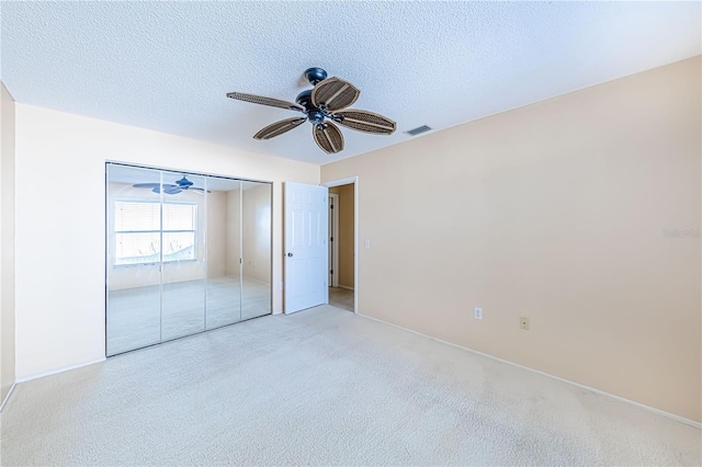 unfurnished bedroom featuring a textured ceiling, ceiling fan, and a closet