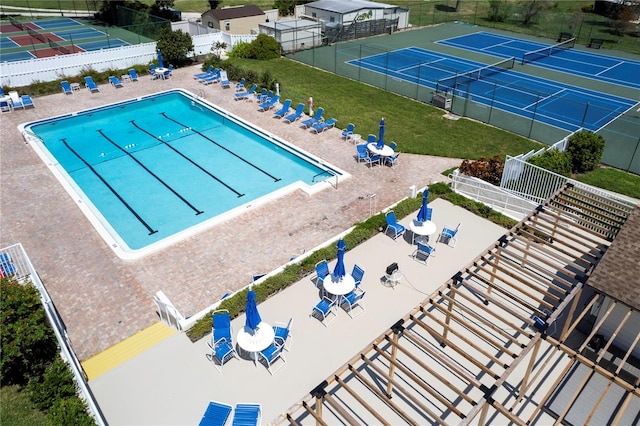 view of swimming pool with a lawn, a patio, and tennis court