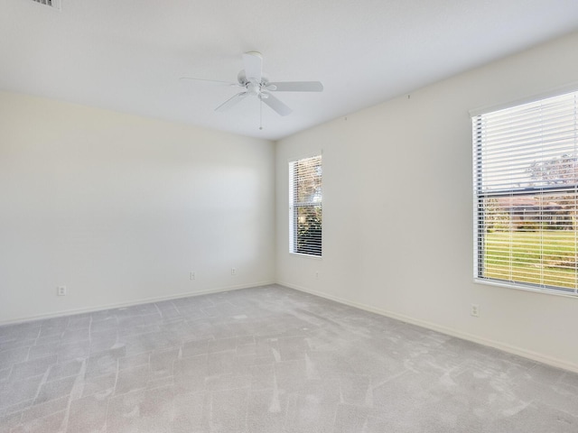 spare room featuring light carpet and ceiling fan