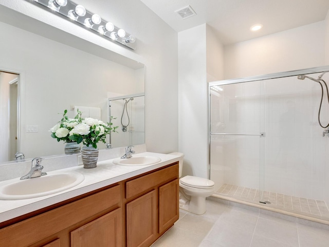 bathroom featuring vanity, toilet, tile patterned floors, and a shower with door