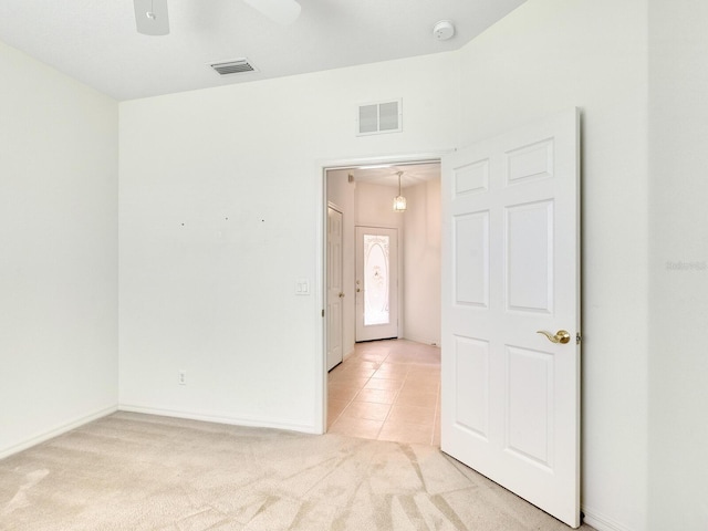 carpeted spare room featuring ceiling fan