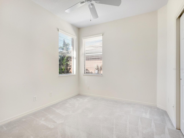 empty room featuring ceiling fan and light colored carpet