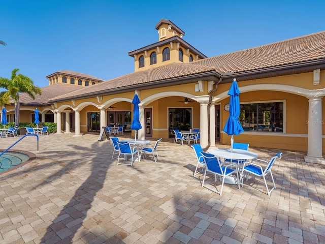 back of house with ceiling fan and a patio