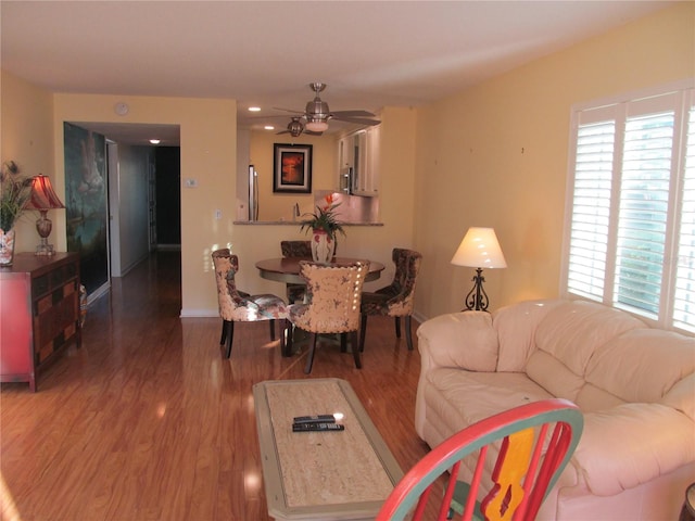 living room featuring ceiling fan and hardwood / wood-style flooring