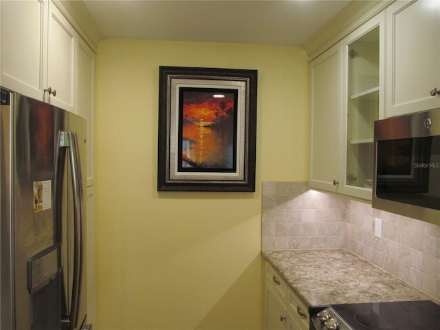 kitchen featuring white cabinetry, backsplash, and appliances with stainless steel finishes