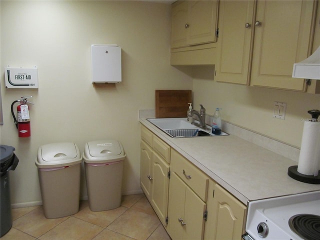 laundry area featuring cabinets, light tile patterned floors, and sink