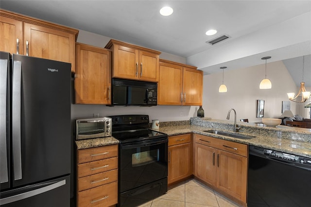 kitchen featuring sink, stone counters, black appliances, decorative light fixtures, and light tile patterned floors