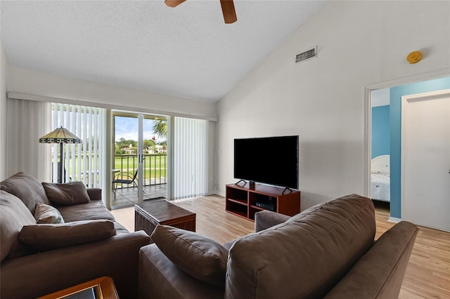 living room with high vaulted ceiling, ceiling fan, and light hardwood / wood-style flooring