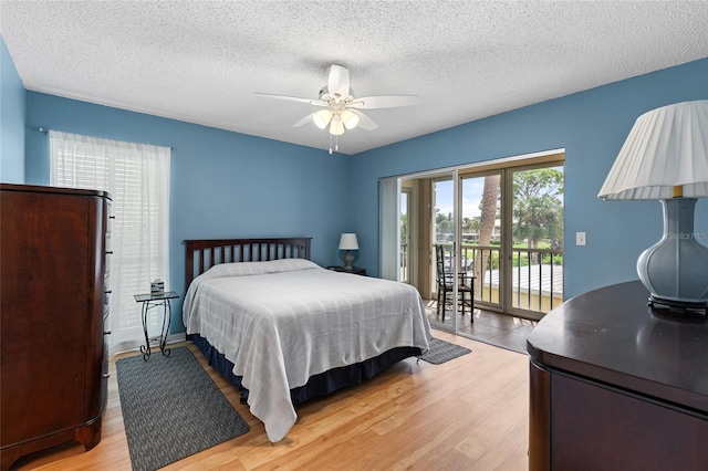 bedroom with light hardwood / wood-style floors, ceiling fan, access to exterior, and a textured ceiling