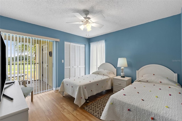 bedroom with ceiling fan, a textured ceiling, a closet, and light hardwood / wood-style floors