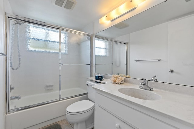 full bathroom featuring vanity, tile patterned flooring, toilet, and combined bath / shower with glass door