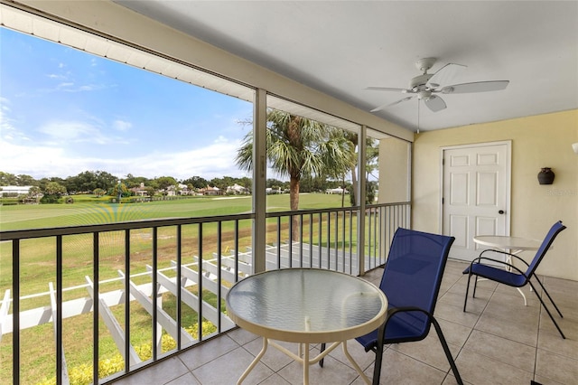 sunroom / solarium with ceiling fan and golf course view