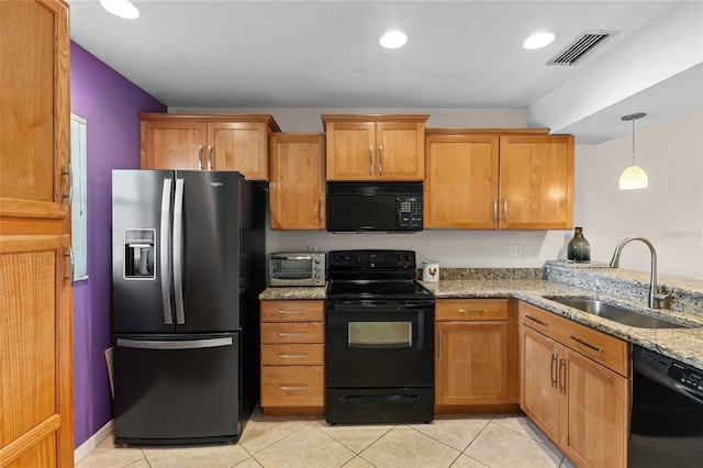 kitchen with light tile patterned floors, visible vents, light stone counters, black appliances, and a sink