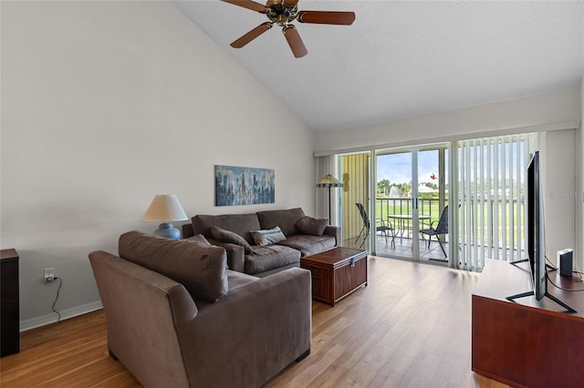 living area with high vaulted ceiling, light wood-style flooring, baseboards, and ceiling fan