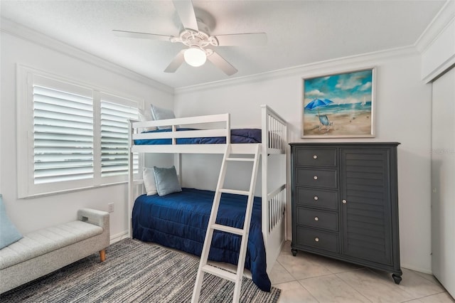 bedroom with ceiling fan, light tile patterned floors, a textured ceiling, and ornamental molding