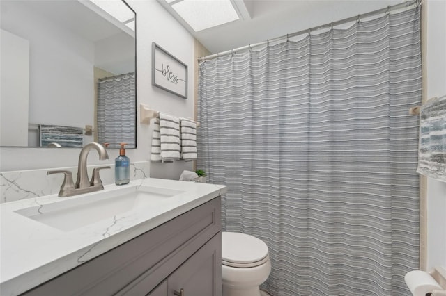 bathroom with vanity, a skylight, and toilet