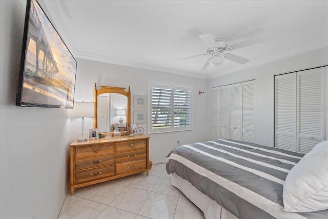 bedroom with ceiling fan, crown molding, and two closets