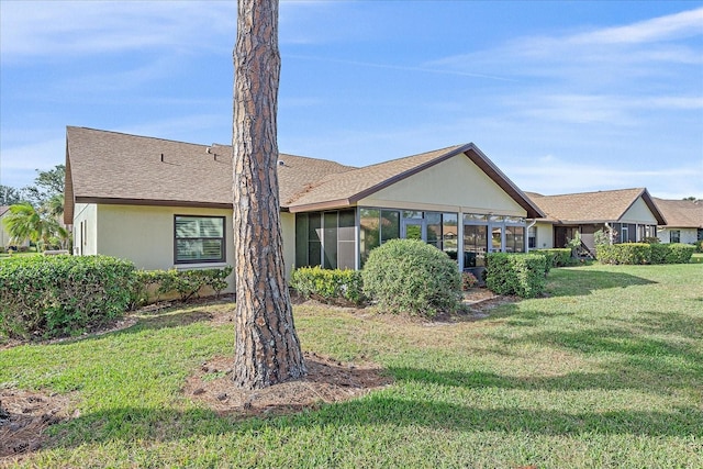 view of front of property with a front yard and a sunroom