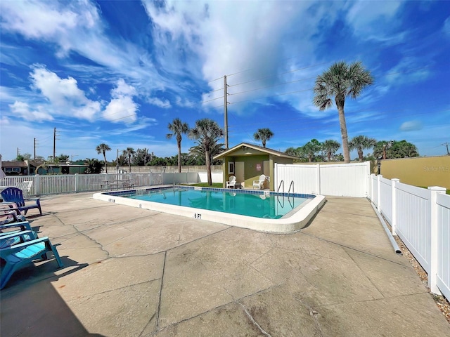 view of pool featuring an outbuilding and a patio