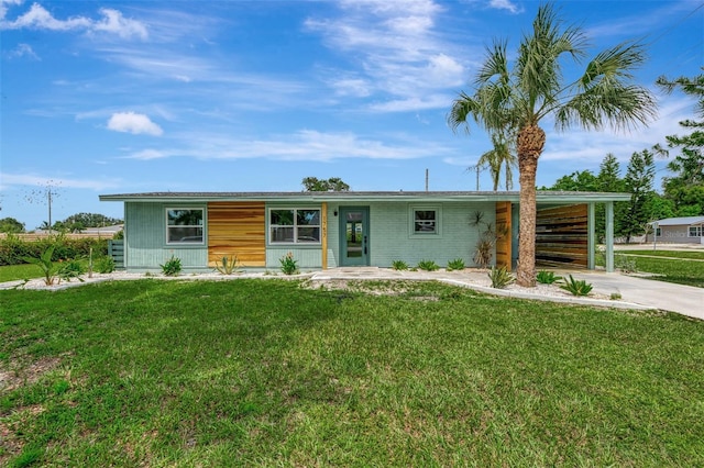 view of front of property with a front yard, an attached carport, and driveway